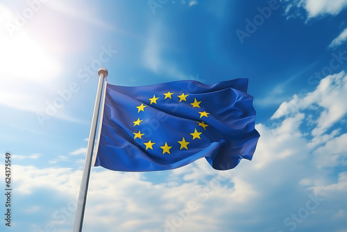European flag flying in the wind on a flagpole against a blue sky with clouds. Blue flag of the European Union wallpaper. 