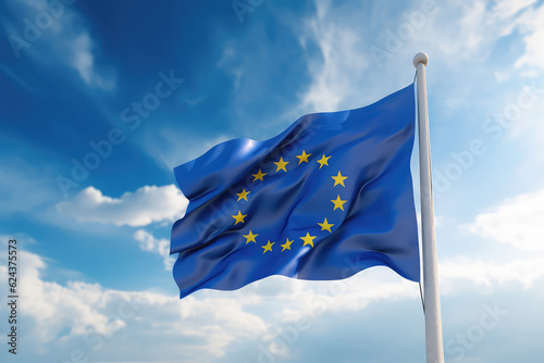 European flag flying in the wind on a flagpole against a blue sky with clouds. Blue flag of the European Union wallpaper. 