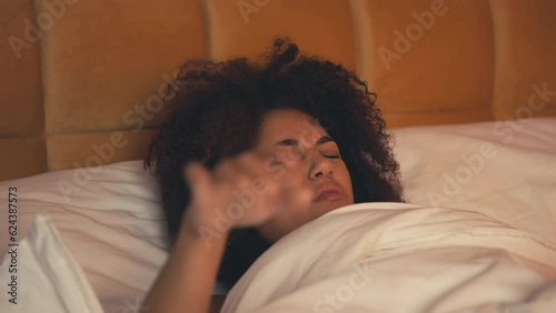 Hungover African American woman waking up in bed after party, having migraine photo
