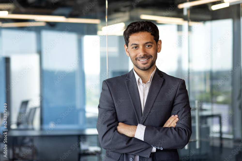Portrait of successful mature boss, senior businessman in business suit looking at camera and smiling, man with crossed arms working inside modern office building Portrait of successful mature boss, senior businessman in business suit looking at camera and smiling, man with crossed arms working inside modern office building