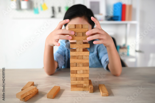 Принти на полотні Child Boy Playing Jenga Game Exciting on Desk at Home