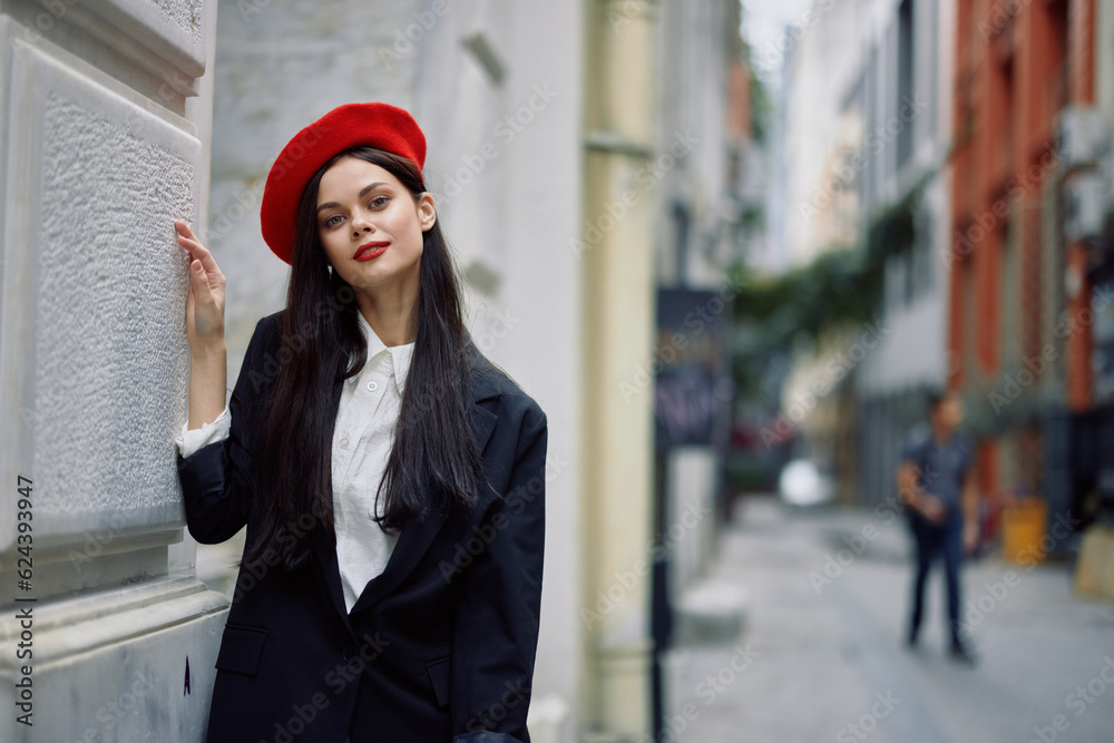 Woman standing near a wall in the city wearing a stylish jacket and red beret with red lips, travel and leisure, French style of dress, spring. Woman standing near a wall in the city wearing a stylish jacket and red beret with red lips, travel and leisure, French style of dress, spring.