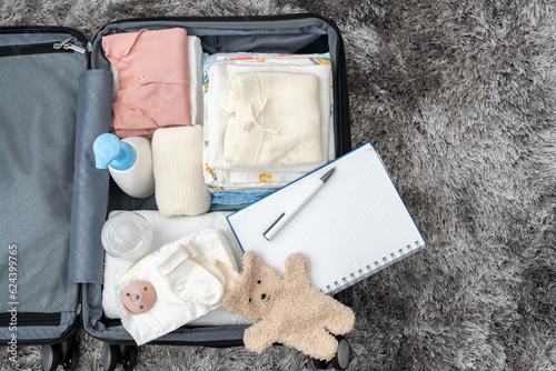 Open bag for maternity hospital. Suitcase of baby clothes prepared for newborn birth. Concept of getting ready for the maternity hospital, packing baby stuff