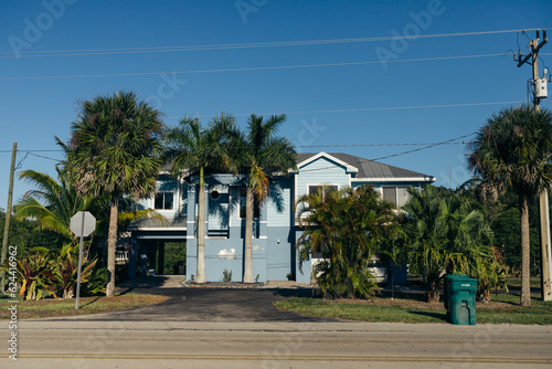 American blue house surrounded with palm trees