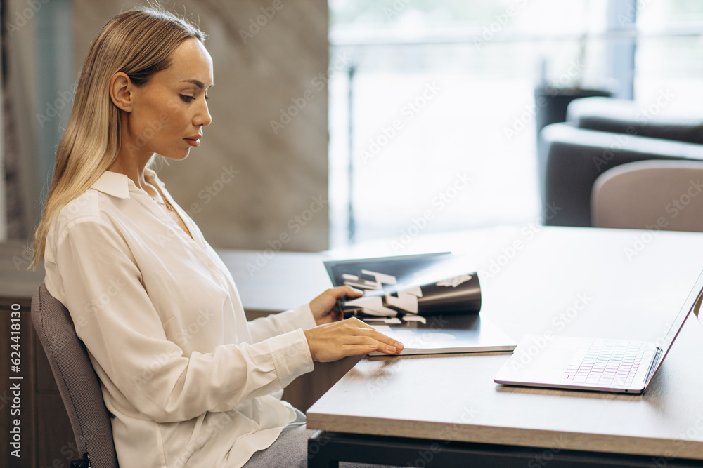 Woman working on laptop in building market with tiles Woman working on laptop in building market with tiles