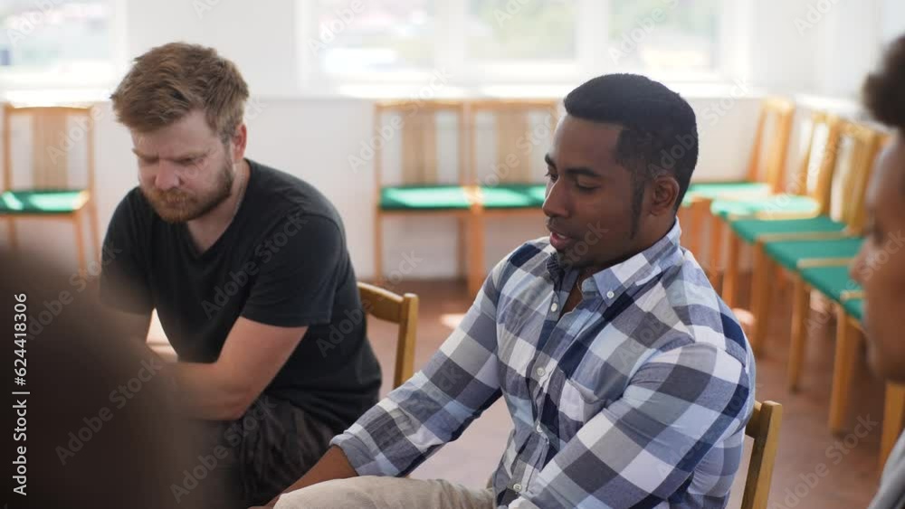 Close-up selective focus shot of pensive sad african american man discussing alcohol addiction at therapy session. Black male making confession in front of support group people, slow motion. Close-up selective focus shot of pensive sad african american man discussing alcohol addiction at therapy session. Black male making confession in front of support group people, slow motion.