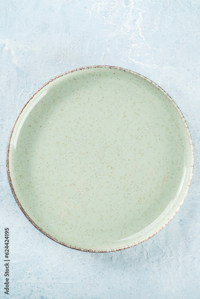 An empty green plate, top shot on a slate background, simple tableware An empty green plate, top shot on a slate background, simple tableware