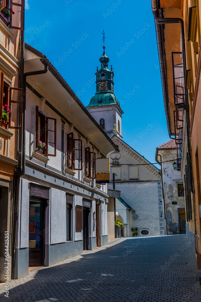 A view up a deserted backstreet towards the cathedral in the old town of Skofja Loka, Slovenia in summertime
