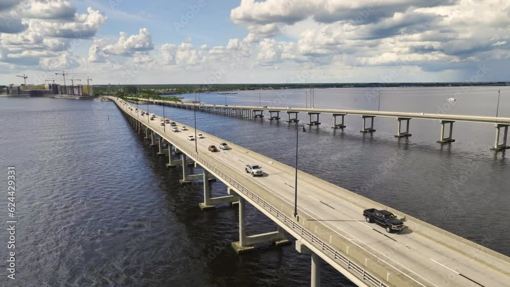 Aerial view of Barron Collier Bridge and Gilchrist Bridge in Florida with moving traffic. Transportation infrastructure in Charlotte County connecting Punta Gorda and Port Charlotte over Peace River Aerial view of Barron Collier Bridge and Gilchrist Bridge in Florida with moving traffic. Transportation infrastructure in Charlotte County connecting Punta Gorda and Port Charlotte over Peace River