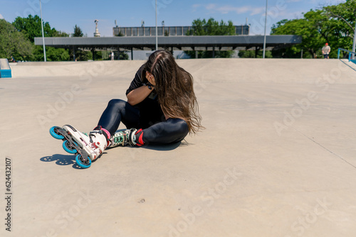 upset girl crying after falling on rollers on a roller rink unsuccessful skating injury active recreation hobby