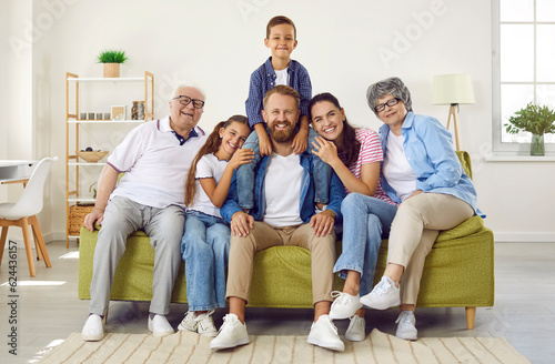 Fotografia Portrait of happy, friendly and loving family of three generations sitting together on sofa at home