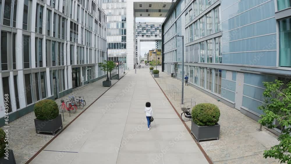 Woman walk at famous crane houses new architecture at the Rhine river, slow motion aerial shot Woman walk at famous crane houses new architecture at the Rhine river, slow motion aerial shot
