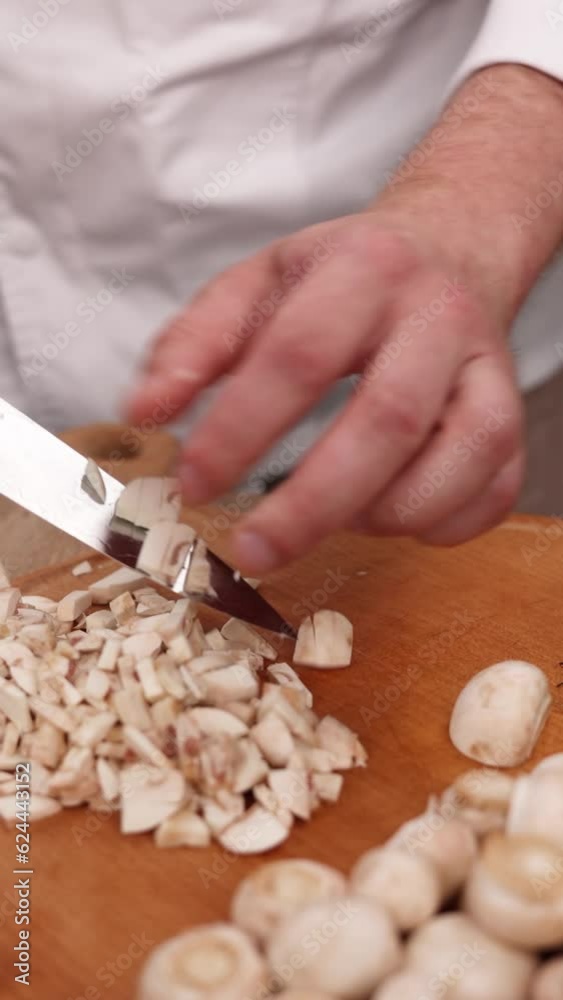 The chef prepares a delicious dish with mushrooms in the kitchen. Close-up The chef prepares a delicious dish with mushrooms in the kitchen. Close-up