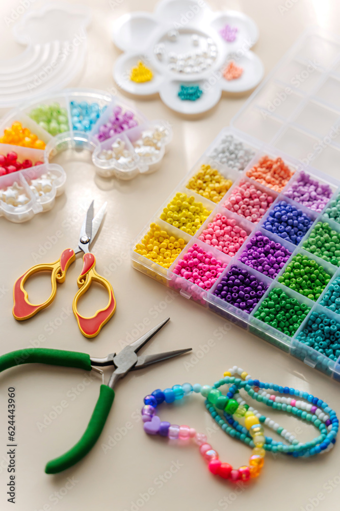 Set of for needlework and beading with tools for making jewelry. Handmade bracelets and different beads for children's crafts in boxes. DIY art activity for kids. Motor skills, creativity and hobby. Set of for needlework and beading with tools for making jewelry. Handmade bracelets and different beads for children's crafts in boxes. DIY art activity for kids. Motor skills, creativity and hobby.