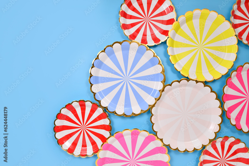 Colorful striped paper party plates on blue background
