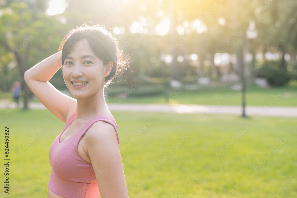 Experience the joy of wellness living as a happy, beautiful Asian woman in her 30s smiles and looks at the camera in a park at sunset. Experience the joy of wellness living as a happy, beautiful Asian woman in her 30s smiles and looks at the camera in a park at sunset.