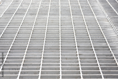 A background image of a corridor built from gray steel grating panels.