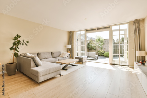 a living room with wood flooring and sliding glass doors leading to the outside patio area in an apartment building