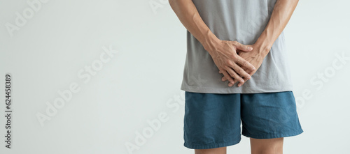 Canvas Print Man hold hand in front of private parts feeling discomfort from disease and inflammation