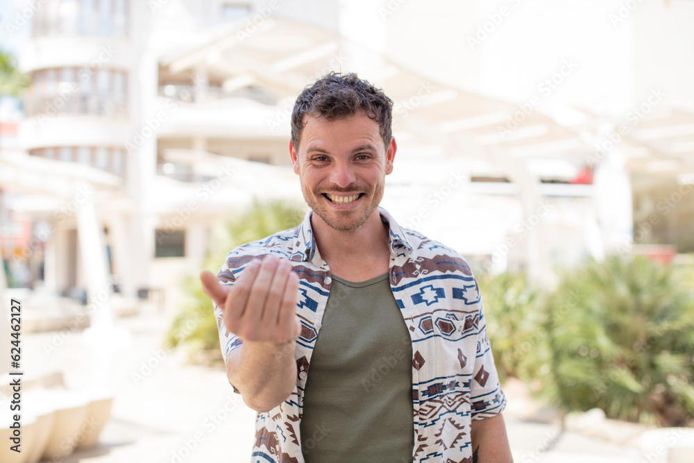 Obraz premium handsome man feeling happy, successful and confident, facing a challenge and saying bring it on! or welcoming you