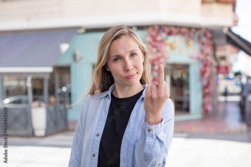 Fototapeta premium pretty woman feeling angry, annoyed, rebellious and aggressive, flipping the middle finger, fighting back