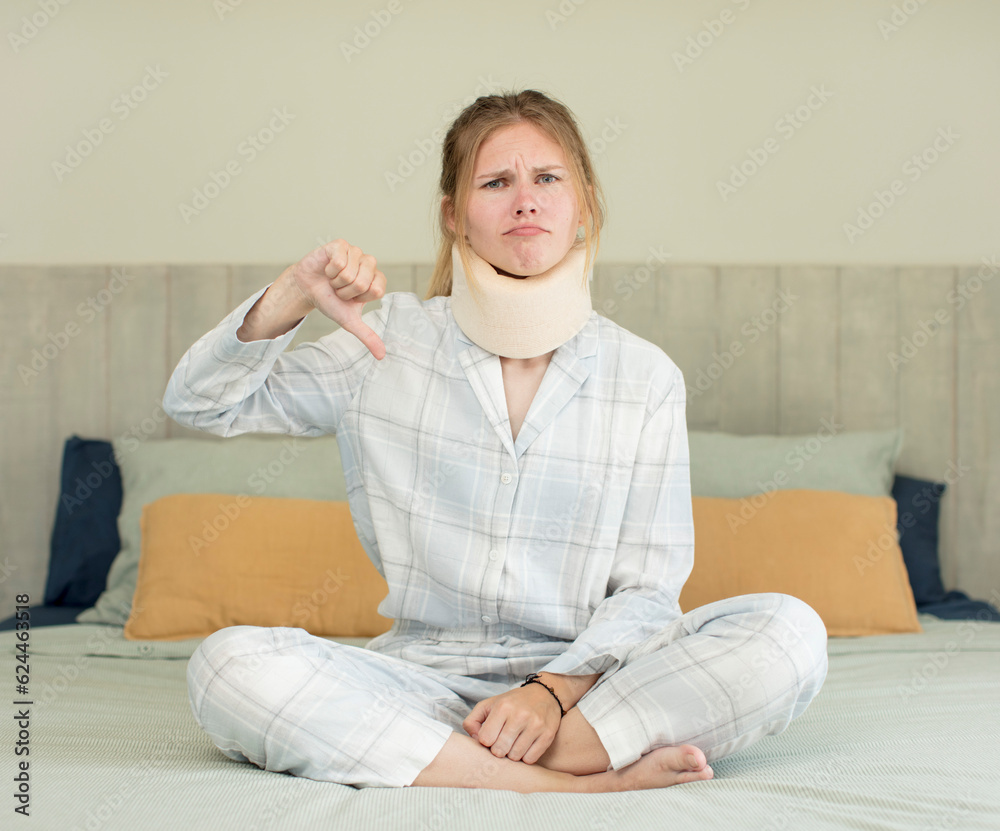 young pretty woman feeling cross,showing thumbs down. accident collar concept young pretty woman feeling cross,showing thumbs down. accident collar concept
