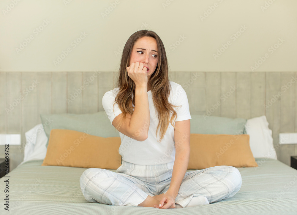 pretty woman feeling scared, worried or angry and looking to the side. nightwear and bedroom concept pretty woman feeling scared, worried or angry and looking to the side. nightwear and bedroom concept
