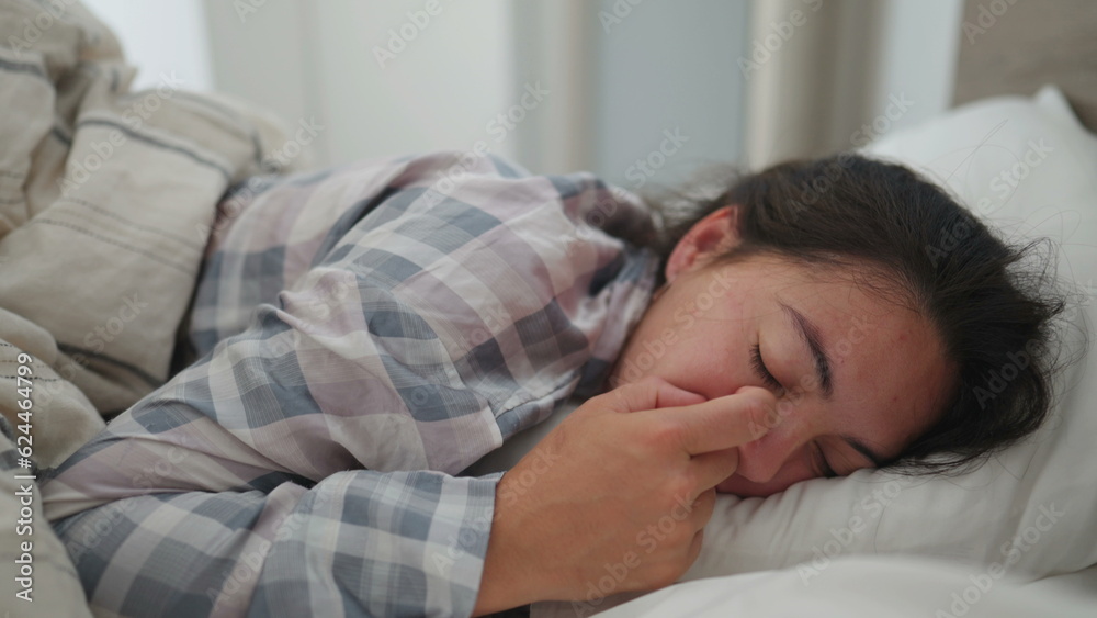 Woman lying in bed in the morning waking up from sleep Woman lying in bed in the morning waking up from sleep