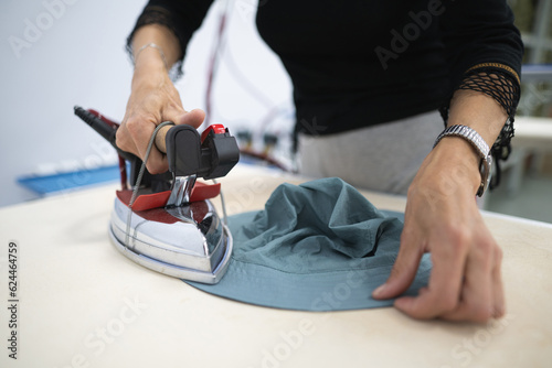 a worker irons clothes at a sewing factory