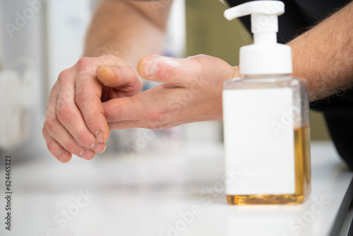 applying and rubbing the cosmetic product from the bottle into the hand