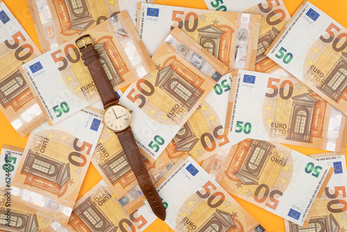 many 50 euro bills with a watch