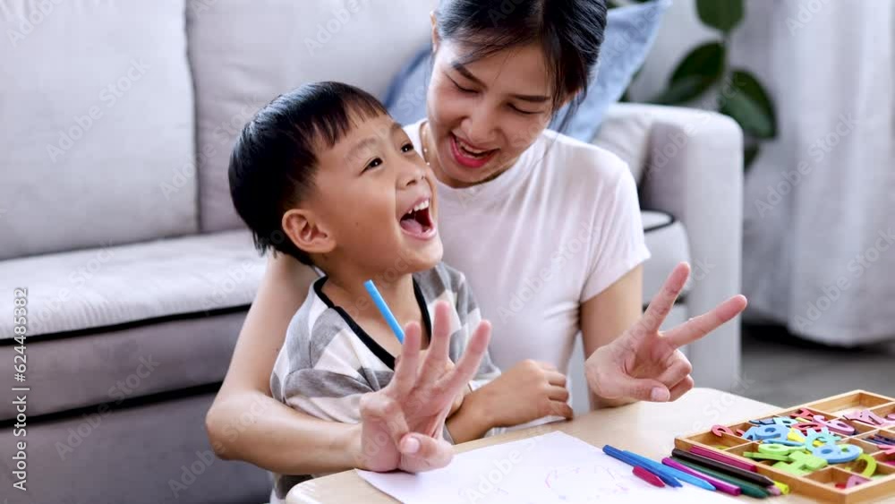 Lifestyle education at home for kids concept, young mom playing or teaching homework for son sitting on floor at home in living room, cute adorable boy have fun learning to count fingers with mother Lifestyle education at home for kids concept, young mom playing or teaching homework for son sitting on floor at home in living room, cute adorable boy have fun learning to count fingers with mother