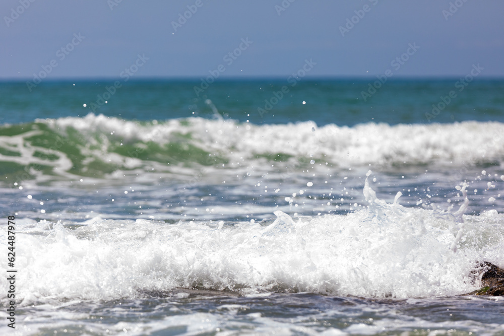Sea waves with foam rolling onto the shore