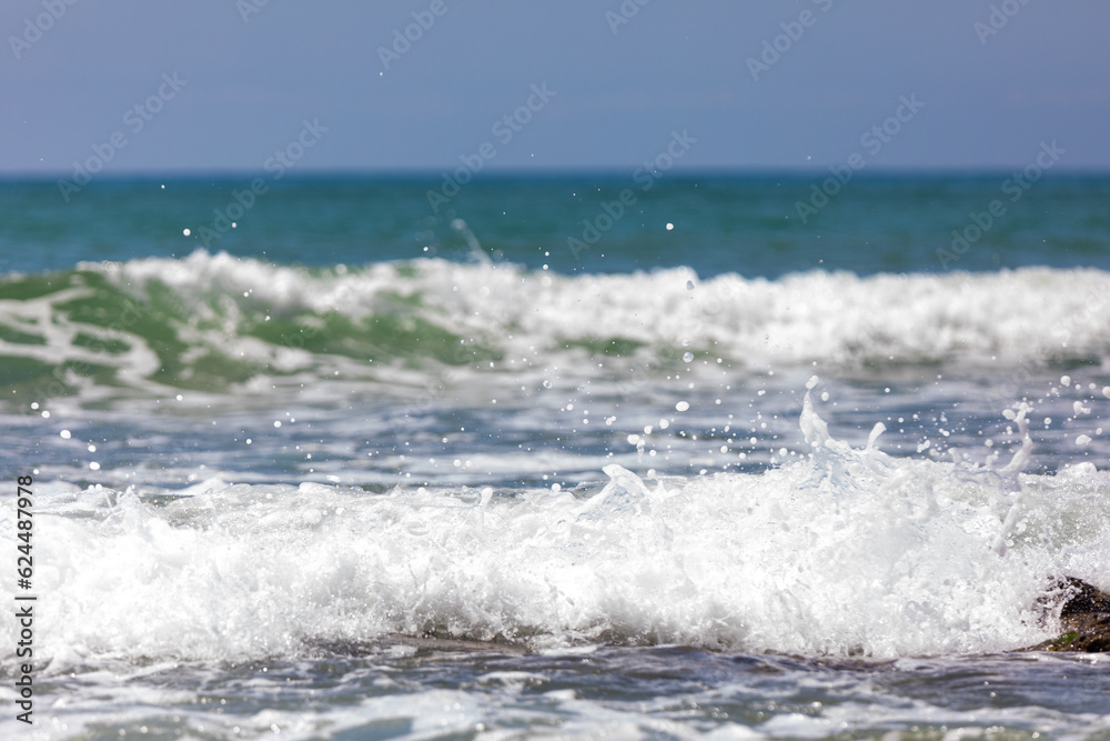 Sea waves with foam rolling onto the shore Sea waves with foam rolling onto the shore