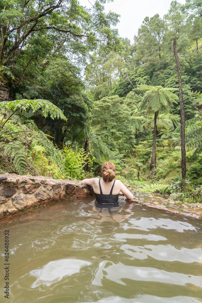 Fototapeta premium Woman in the hot springs of Caldeira Velha in Sao Miguel island of the Azores.