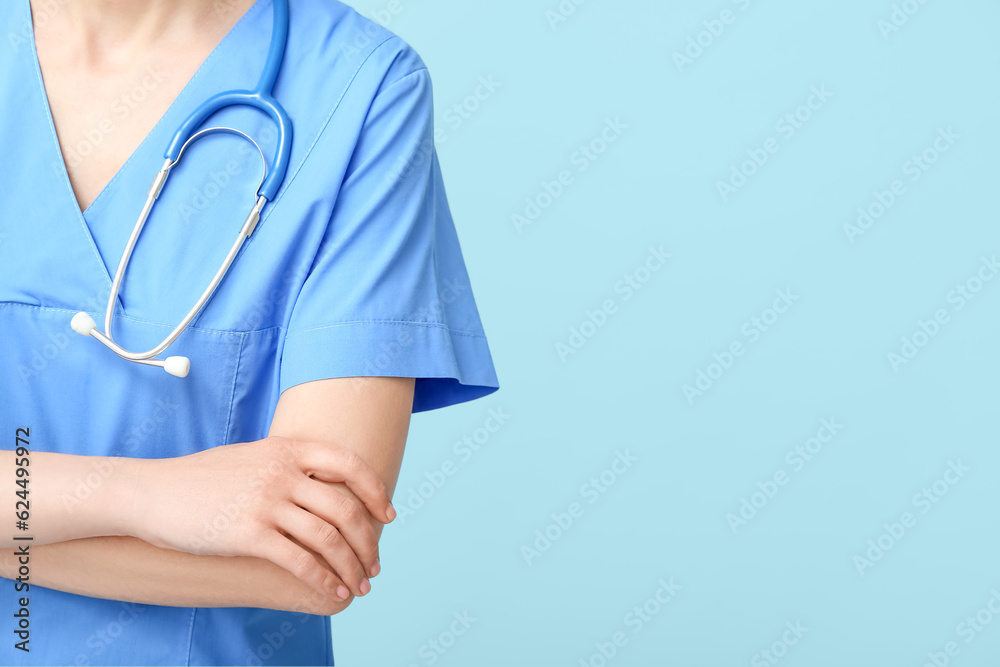 Female doctor in coat with stethoscope on blue background Female doctor in coat with stethoscope on blue background
