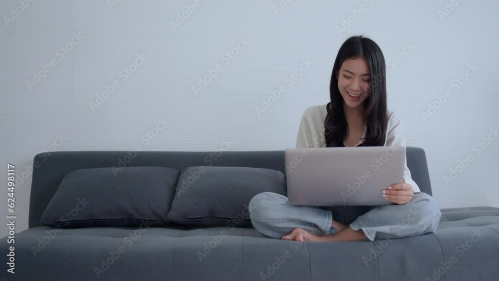 Asian Woman Working from the Comfort of Her Bedroom with Her Adorable Pet by Her Side. Asian Woman Working from the Comfort of Her Bedroom with Her Adorable Pet by Her Side.