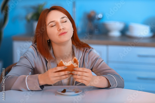 Young woman eating burger i...