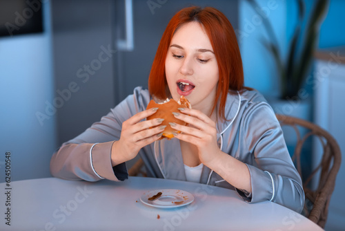 Young woman eating burger i...