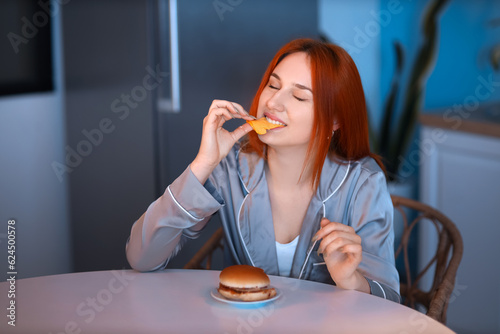 Young woman eating burger i...