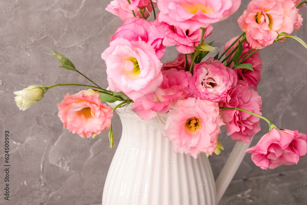 Obraz premium Jug with beautiful pink eustoma flowers on grey background