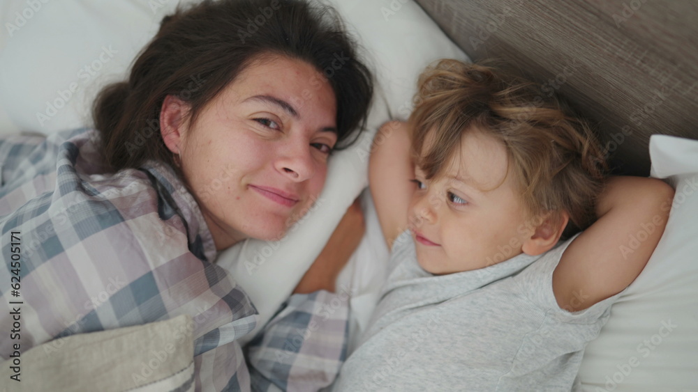 Mother child love and affection in morning bed waking up little boy loving mom family moment Mother child love and affection in morning bed waking up little boy loving mom family moment