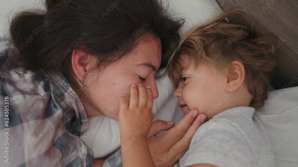 Mother child love and affection in morning bed waking up little boy loving mom family moment Mother child love and affection in morning bed waking up little boy loving mom family moment