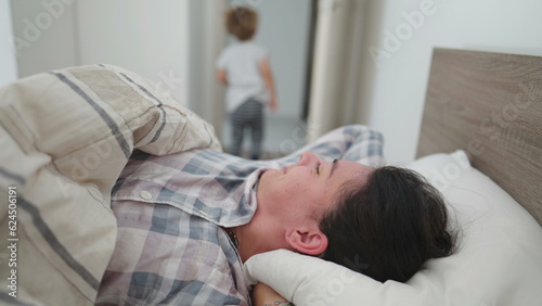 Mother wakes up in morning with child mom getting up from bed