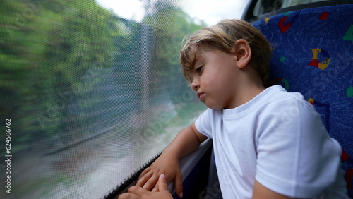 One contemplative child travels by bus leaning head on window