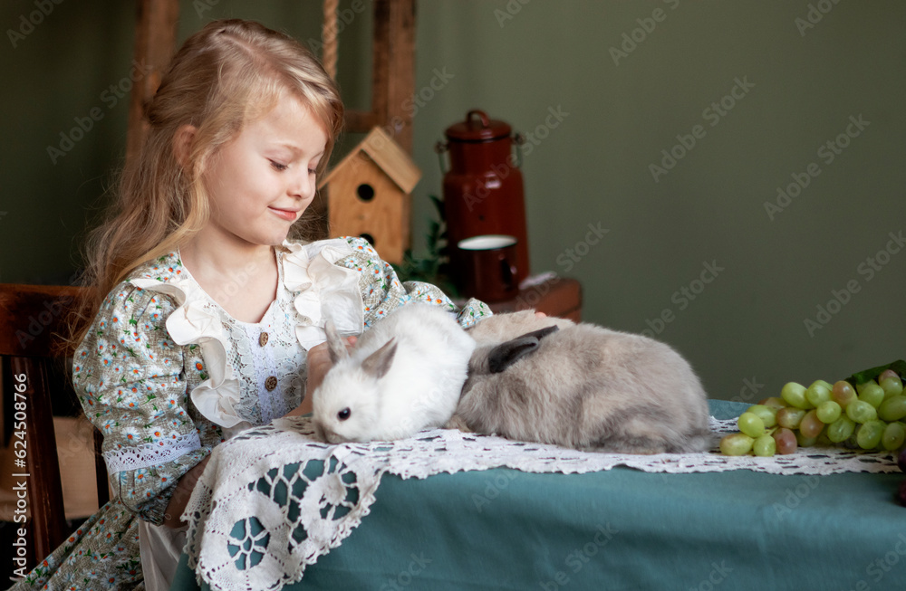 girl with long blond hair with gray rabbits at home. spring day and happy Easter