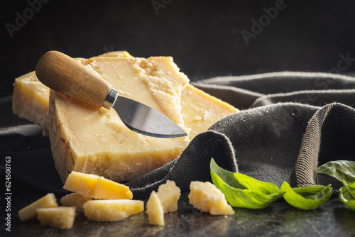 Tasty parmesan cheese on black table.