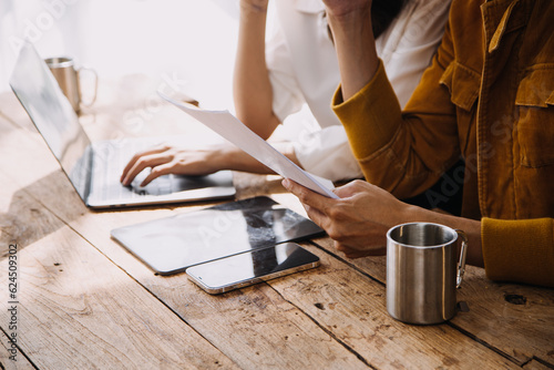 Entrepreneur Asian businessman and businesswoman discussing new business project in tablet in modern Meeting In Modern Office, Asian business casual concept.