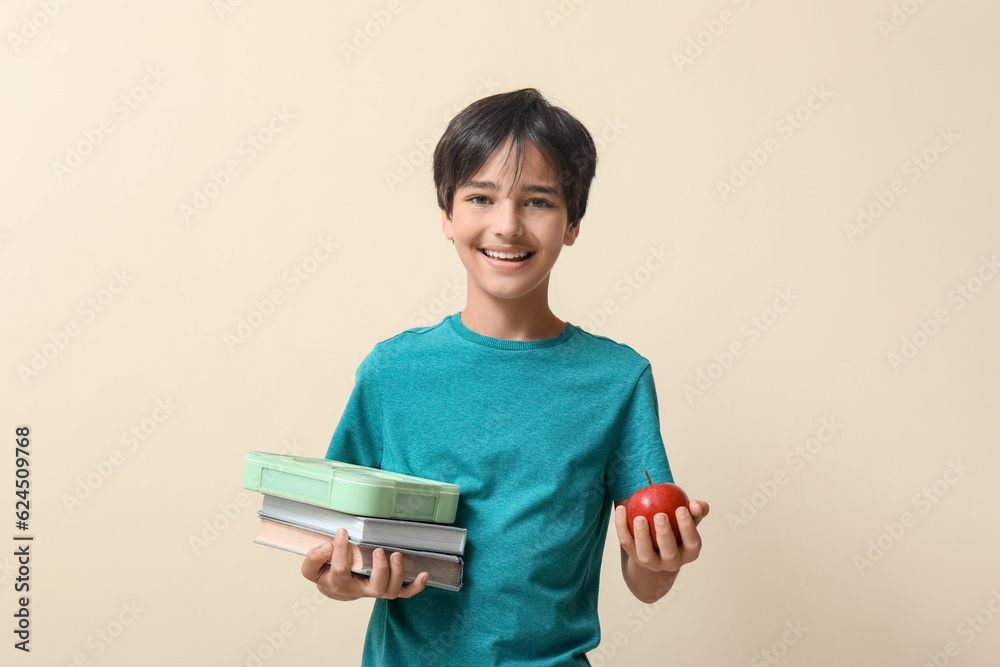 Little boy with lunchbox and apple on beige background Little boy with lunchbox and apple on beige background