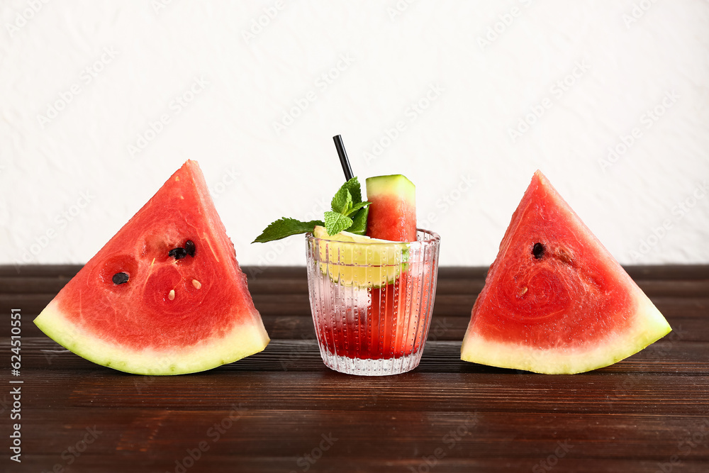 Glass of fresh watermelon lemonade with lime and mint on wooden table Glass of fresh watermelon lemonade with lime and mint on wooden table